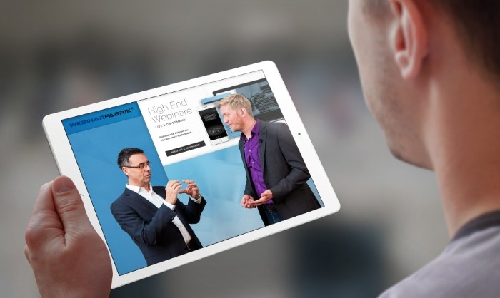 Mann der via Tablet an einem Webinar teilnimmt